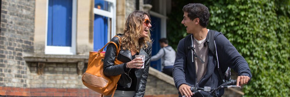 A banner image of two students laughing outside Studio Cambridge Main School, linking to Studio Cambridge Adult English Course testimonials