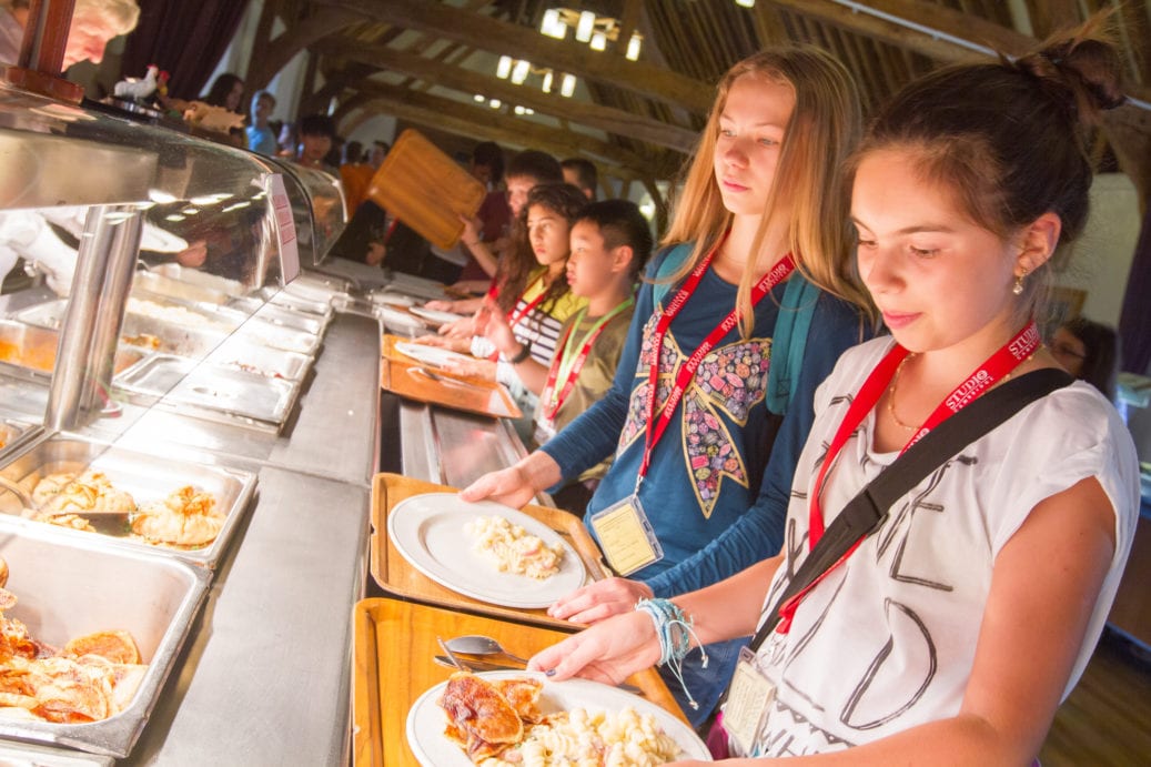 Students choosing breakfast food from King's Ely dining hall at Sir Edward residential English summer camp