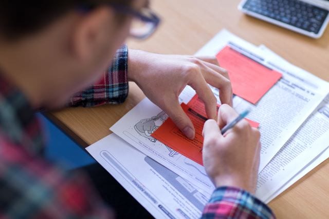 Student making notes on English reading task in class at Studio Cambridge