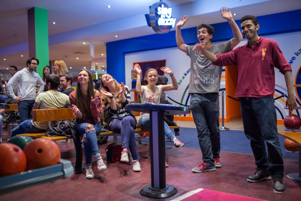 Students cheer as they are bowling on an evening activity.